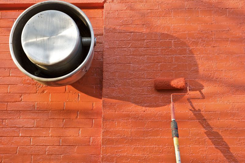Paint roller applying paint to a wall